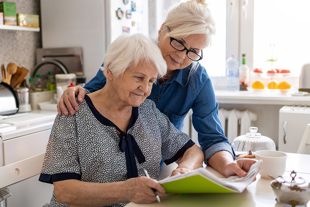 caregiver reviewing hospice care papers with senior lady
